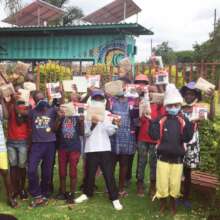 Kids hold up their new solar lights and xmas gifts