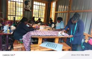 Women learning the process of sewing reusable pads