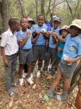 Group of school kids holding up a snare they found