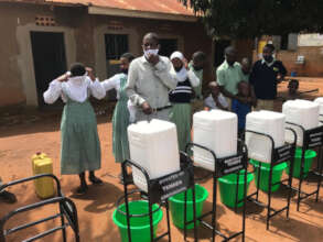 Teacher prepares handwashing stations for students