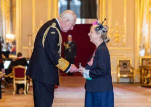 Zoe Walker receiving an MBE from King Charles III