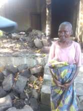 Gogo Hilda next to her house which collapsed