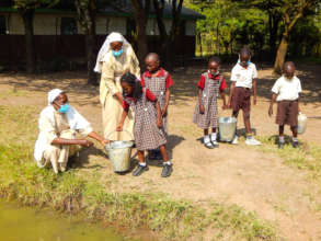 Kindergarteners fetching water from the Pond