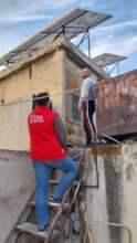 Mussa with the solar panel installed on his house.