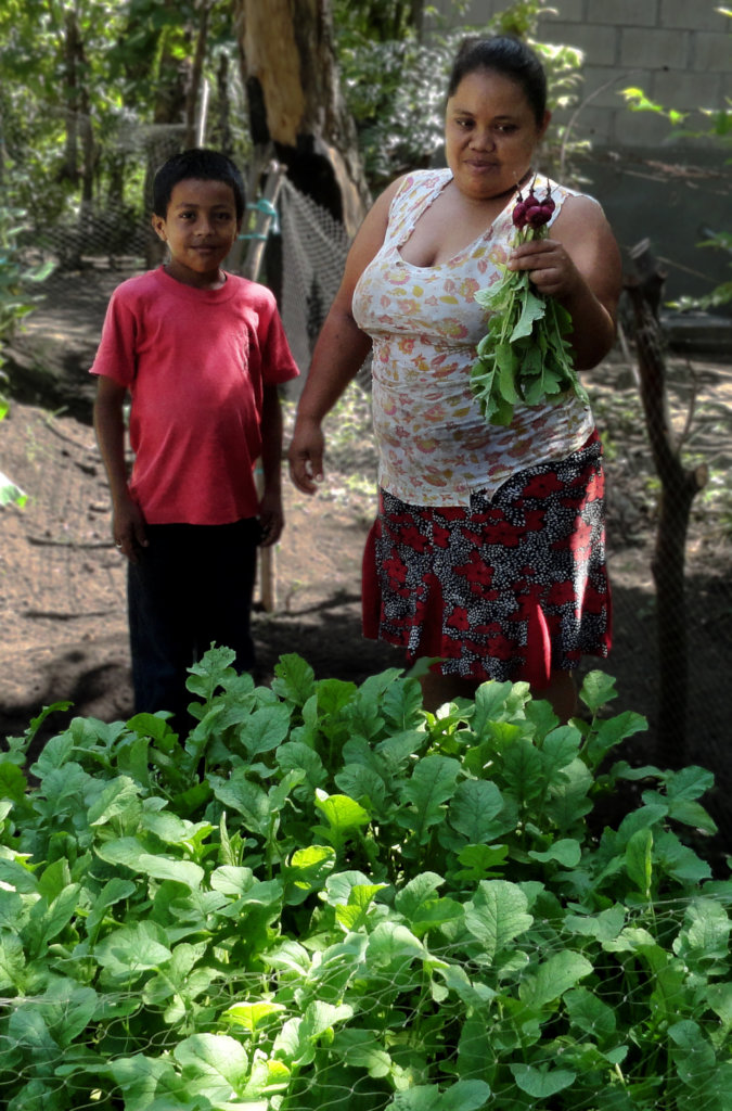 Woman and her son showing their radish crops