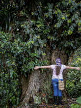 Young female biologist hugging a Black Oak