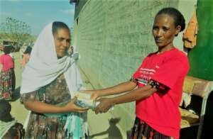 A woman gets a dignity kit from an ActionAider.