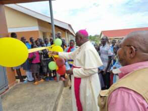 Bishop of Arua cuts the tape of the computer lab
