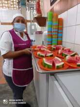 Cook at the School kitchen serving watermelon