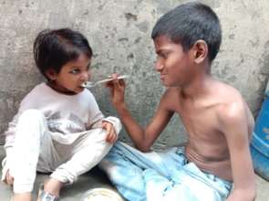 Brother feeding his sister