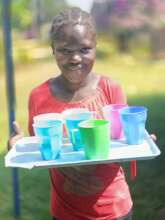 Amina serving children porridge