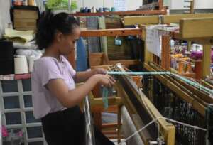 A trainee preparing the threads for weaving