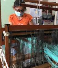 Rosalie Akase doing denting of threads in weaving