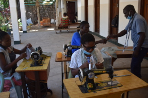 Pius and other students with the tailoring trainer