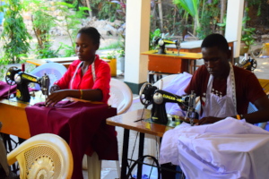 Purity and Pius making uniforms for our children