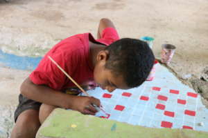 Outside a library, a student paints a chess board