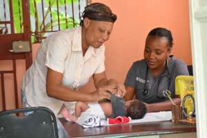 Rosebenette readies her child for examination
