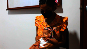 Yassiel carries her baby