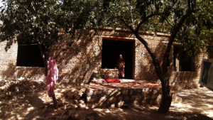 Shakila outside her home