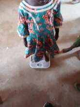 weighing a child during our out reach