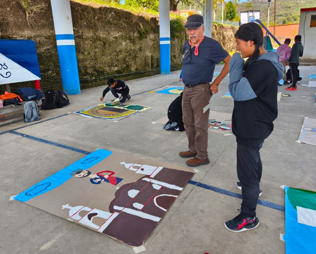 Hector Duarte guides students to create mural