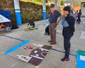 Hector Duarte guides students to create mural