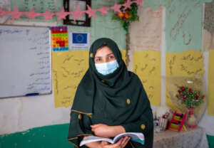 Hajera reads a book aloud to her students.