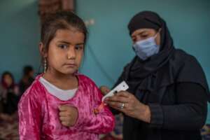 Community health volunteer checks for malnutrition