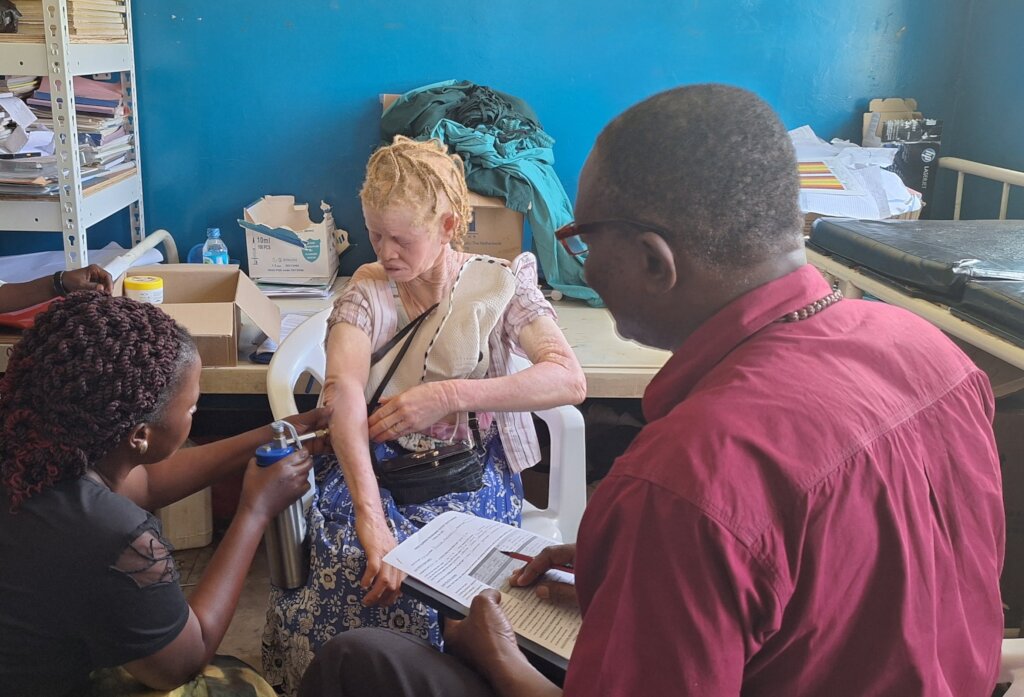A health worker under the guidance of Dr. Ngobi