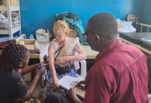 A health worker under the guidance of Dr. Ngobi
