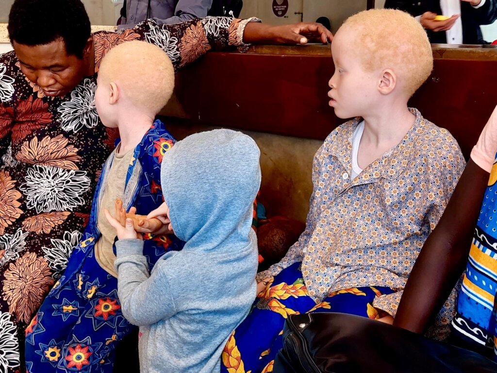 Children wait with their mother for skin checks