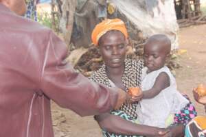 A young girl accepts an apple.