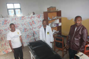 Surrounding the bed: Chairman, Mzunga & Jean Marie