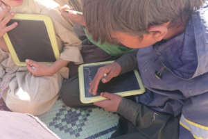 Kids writing on mini chalk board provided by GEC