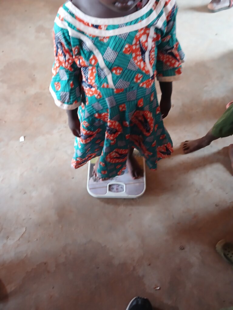 weighing a child during malaria outreach program