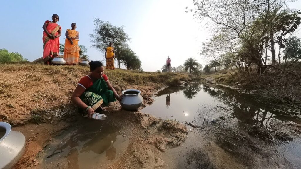 Tribal women at muddy water hole