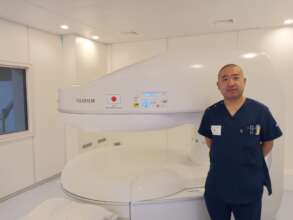 Dr. Hamano next to MRI machine at BNH