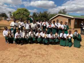 Students receiving learning materials at Minga