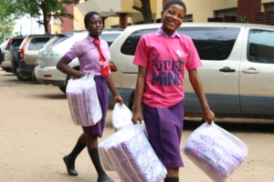 Girls carrying sanitary supplies for their school
