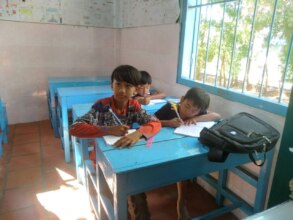 Sopheap is studying and listening to the teacher.