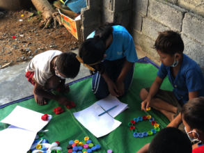 Bopha assists children in a Mobile Library session