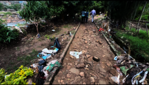 Flood-damaged previously-paved riverside walkway