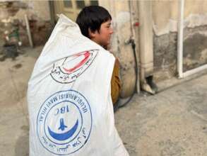 Boy carries food and winter pack home to family