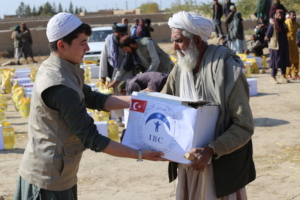 IBC Volunteer helps a village elder with donations