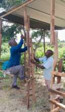 Teacher Ben Mutuku helps build Jeremiah's cow shed