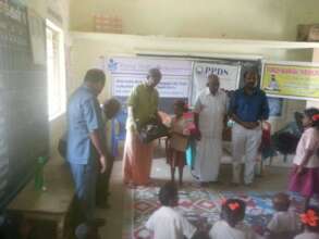 Distribution of note books to the children
