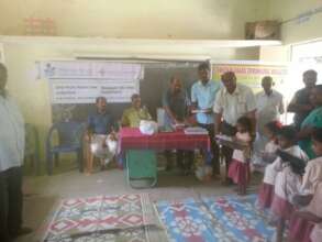 Distribution of note books to the children