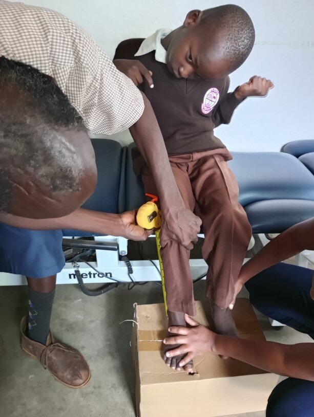 Assessing a young boy for a wheelchair