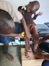 Assessing a young boy for a wheelchair