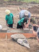 Christopher lays the very first brick!